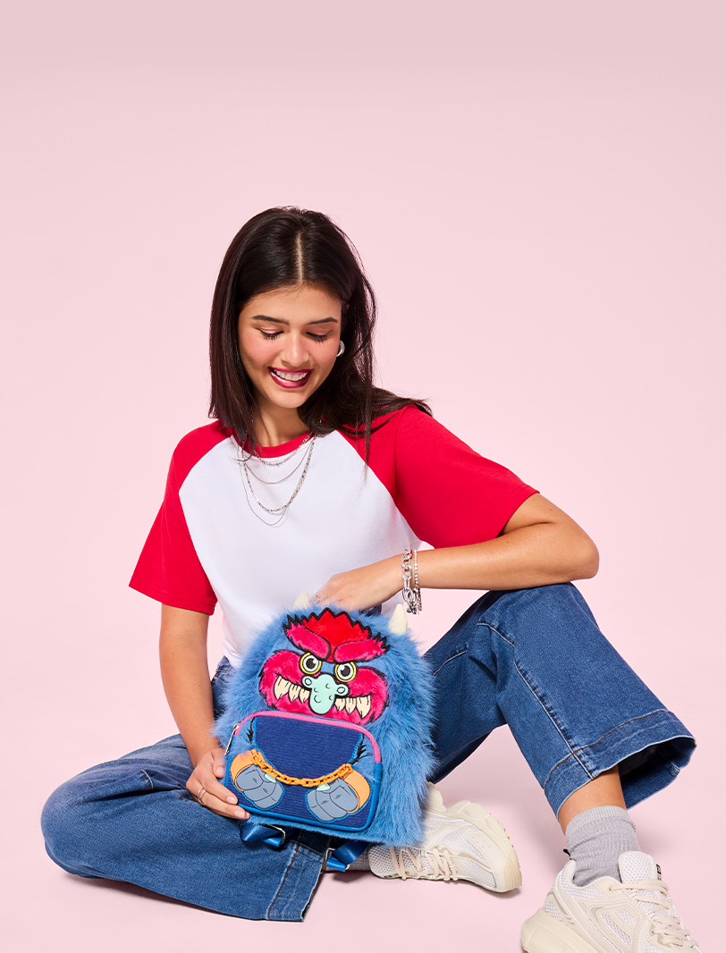 Pink background with model showcasing Loungefly My Pet Monster mini backpack exclusive