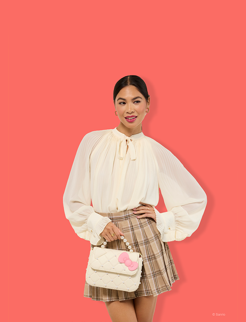 Faded Pink background with model holding Loungefly Hello Kitty crossbody