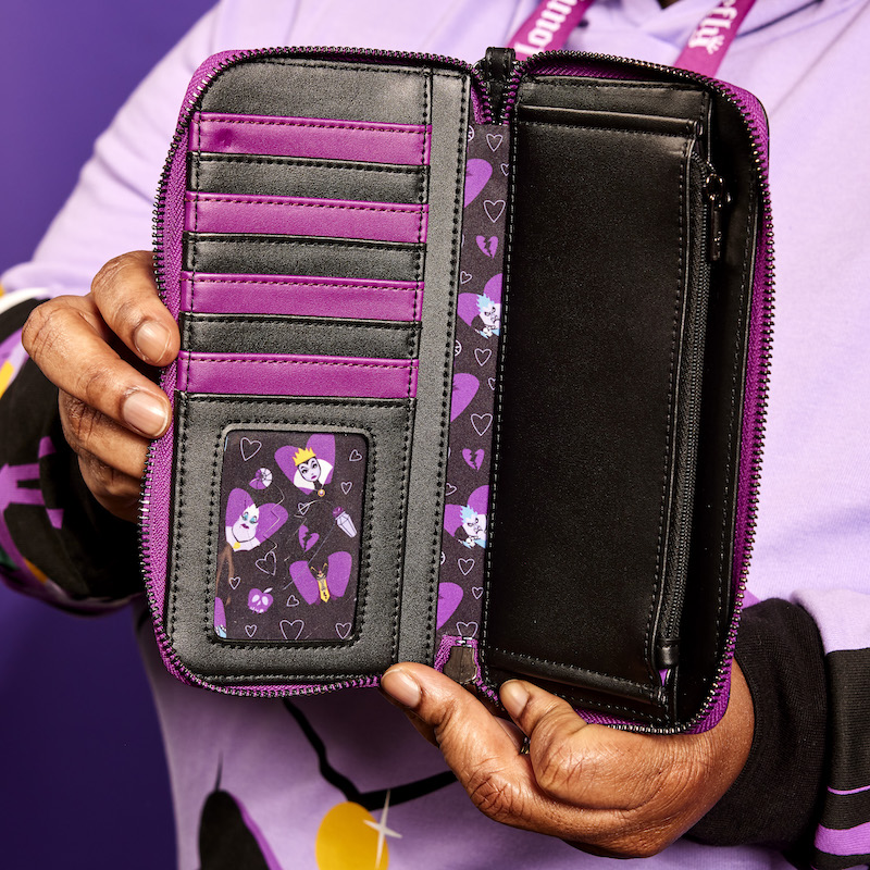 Image of someone holding the Loungefly Disney Villains Curse Your Hearts Zip Around Wristlet Wallet with it open to reveal the seven card slots and clear ID slot. 