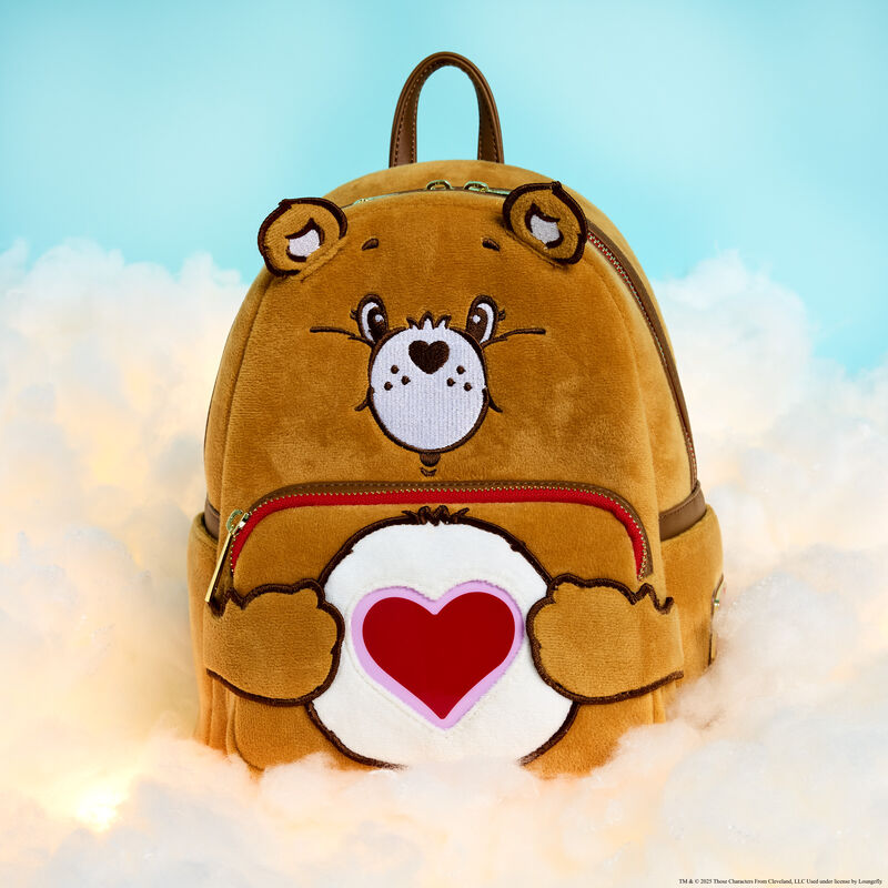 Plush Loungefly Care Bears Tenderheart Bear Mini Backpack sitting on fluffy white clouds against a blue background