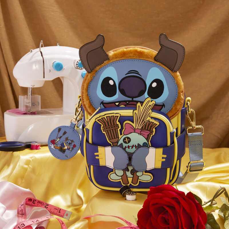 Loungefly Crossbuddies bag featuring Stitch dressed as the Beast from Beauty and the Beast, sitting on yellow silk with a sewing machine and sewing materials around it. 