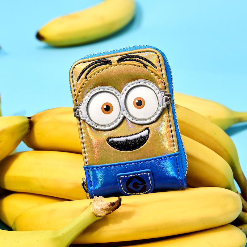 Iridescent Minions accordion wallet sitting on a pile of bananas against a blue background
