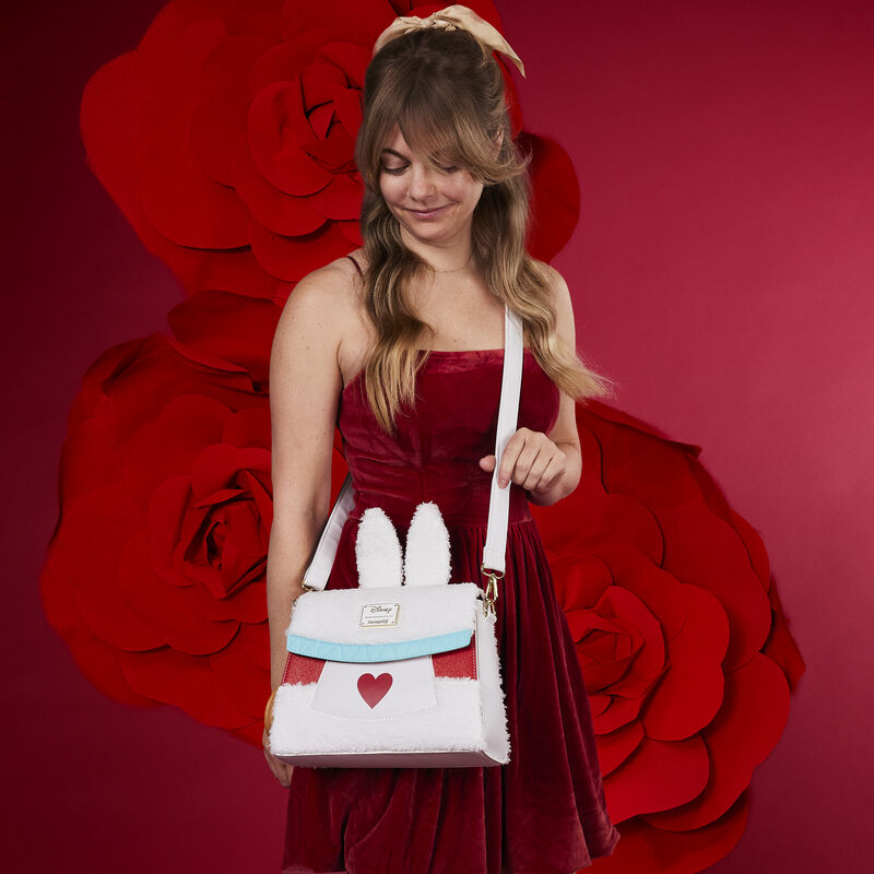 Image of woman wearing the Alice in Wonderland White Rabbit Cosplay Crossbody Bag standing against a red background with roses 