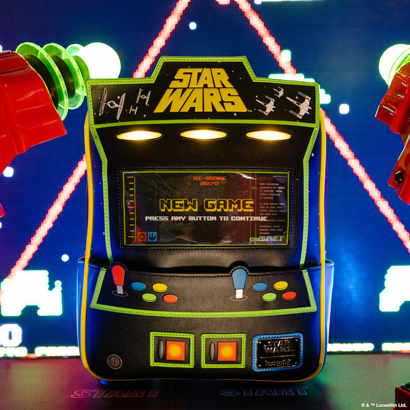 Loungefly mini backpack that looks like a vintage arcade machine with a Star Wars theme against an arcade-themed background