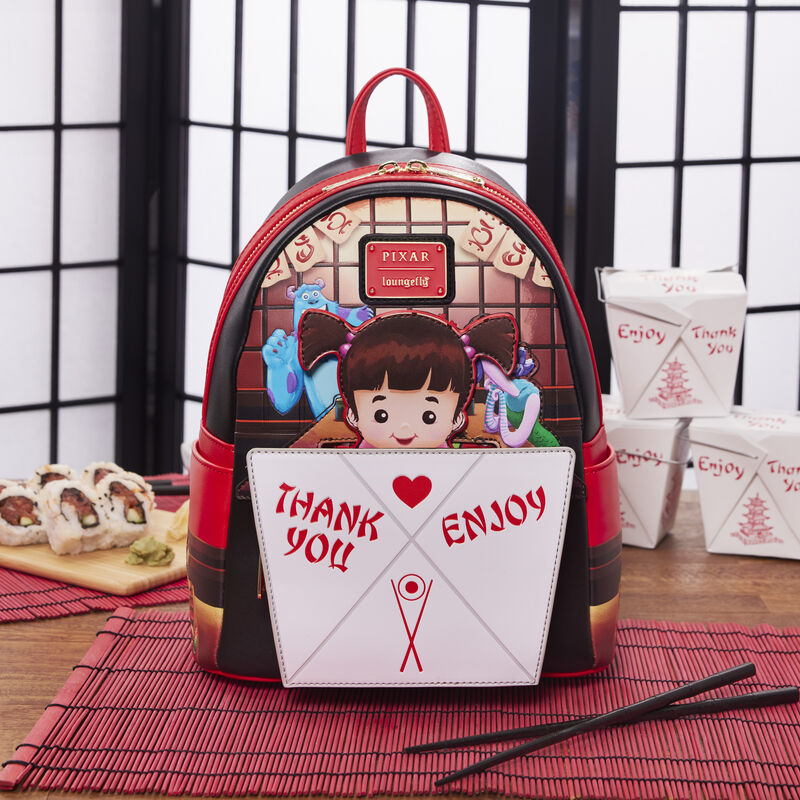 Image of our Loungefly Pixar Monsters, Inc. Harryhausen's Takeout Boo Pop-up Mini Backpack on a table with chopsticks and takeout containers around it