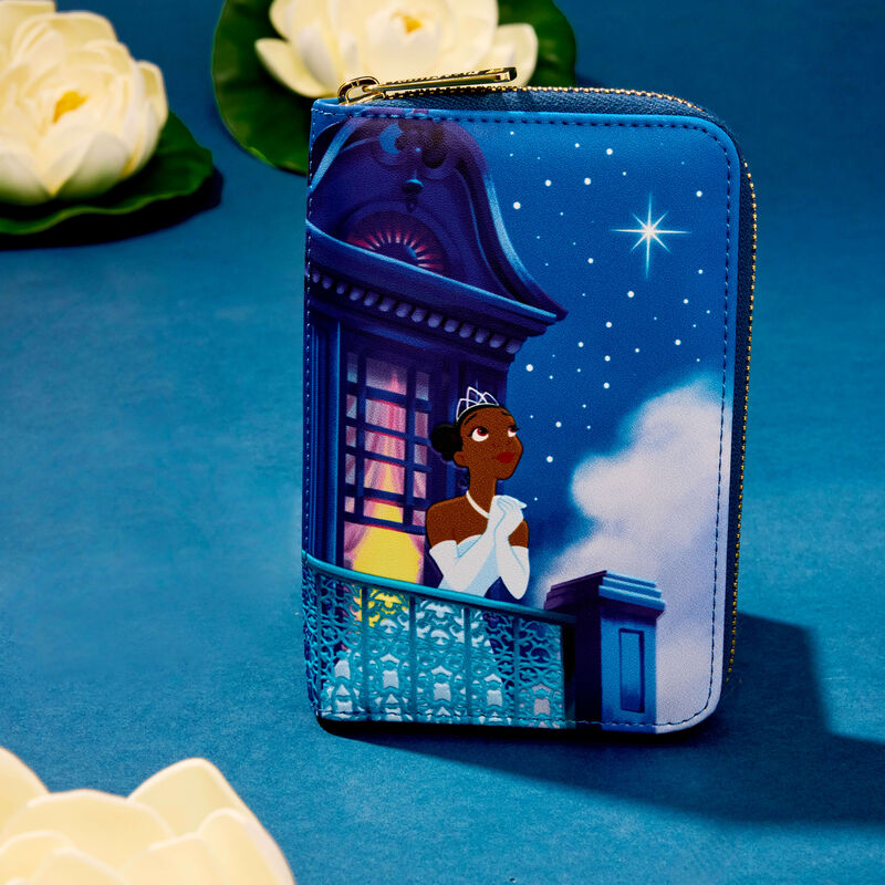 Loungefly zip around wallet featuring an image of Tiana on a balcony looking up at the night sky. The wallet sits against a blue background surrounded by white water lilies. 