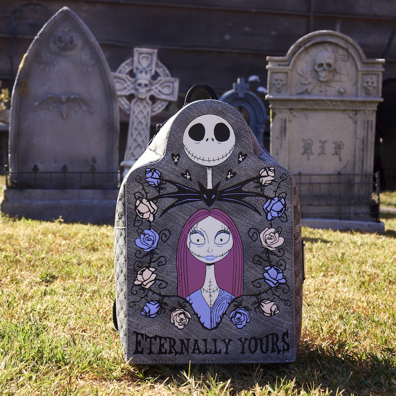 Image of the Loungefly Nightmare Before Christmas Jack and Sally Eternally Yours Tombstone Mini Backpack sitting in a graveyard surrounded by other tombstones