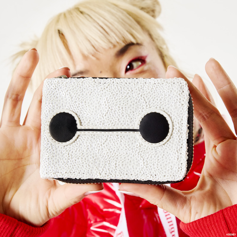 Woman close to camera holding up the Loungefly Disney Big Hero 6 10th Anniversary Baymax Accordion Wallet, featuring Baymax's face with white sequins