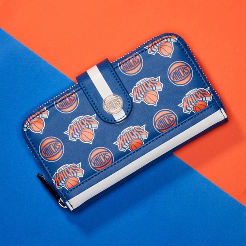 Image of our Knicks Logo Zip Around Wallet against a blue and orange background 
