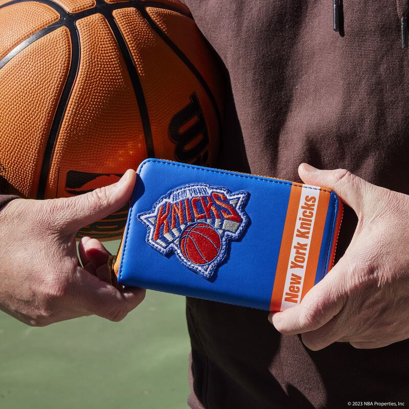 Image of someone holding our Knicks Patch Icons Wallet while also holding a basketball under their arm 