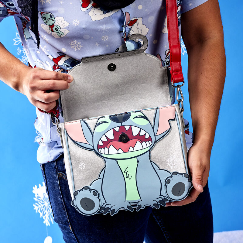 Image of someone wearing our Stitch Holiday Glitter Crossbody Bag with the flap open, showing Stitch with his mouth open 