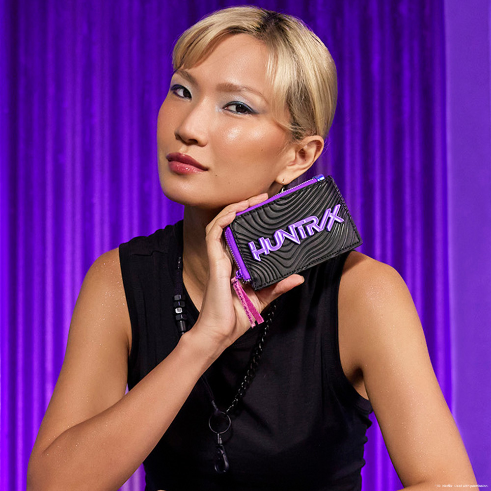 Purple background with model showcasing Loungefly KPop Demon Hunters wallet