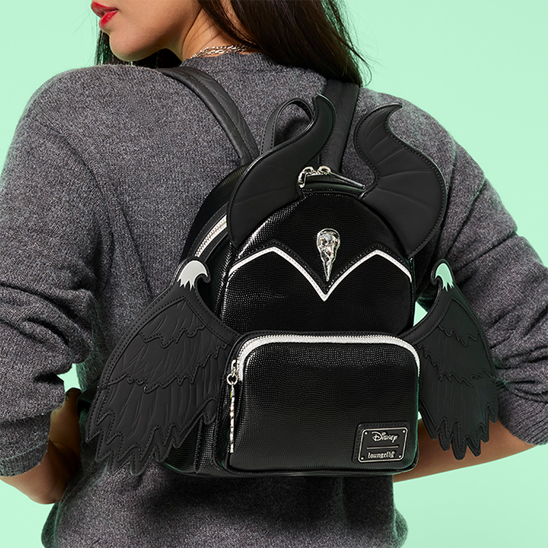 Teal background with model wearing Loungefly Disney Maleficent exclusive mini backpack